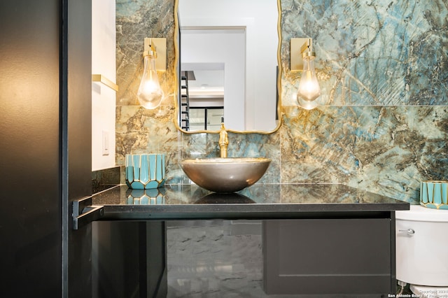 bathroom with decorative backsplash, vanity, and toilet