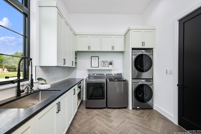 clothes washing area featuring cabinets, parquet floors, separate washer and dryer, and sink