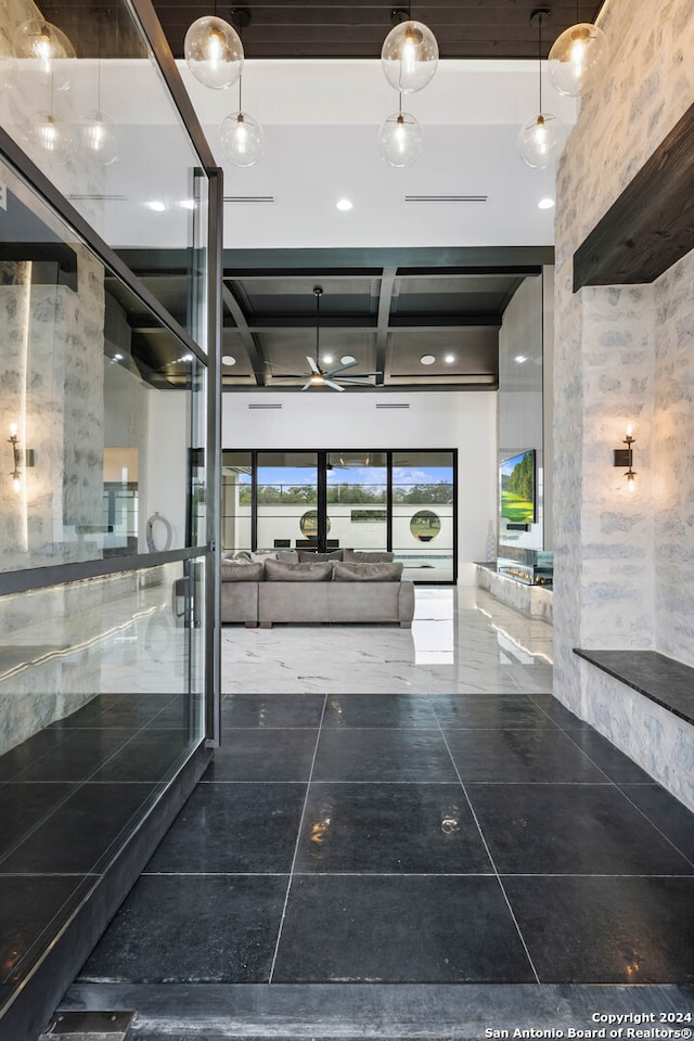 interior space with tile patterned flooring, beamed ceiling, and coffered ceiling