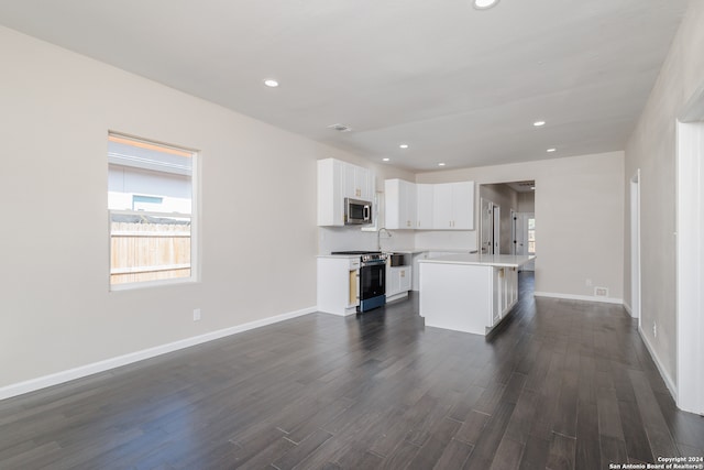 kitchen with white cabinets, stainless steel appliances, dark hardwood / wood-style floors, and a kitchen island