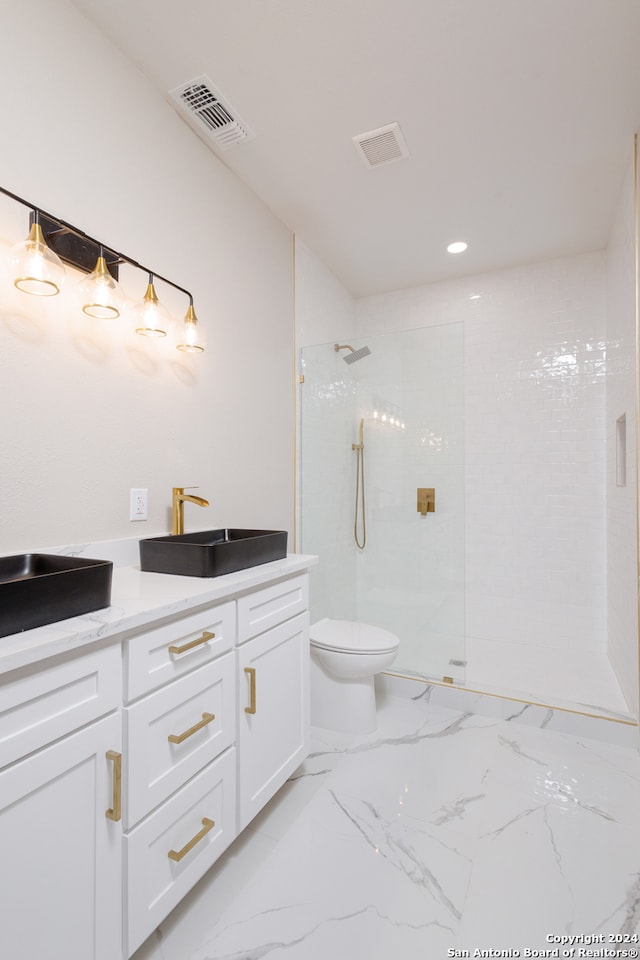 bathroom with a tile shower, vanity, and toilet