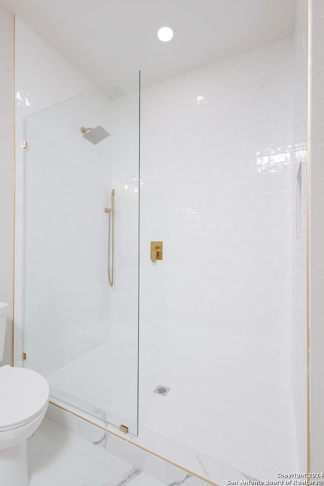 bathroom featuring toilet and tiled shower