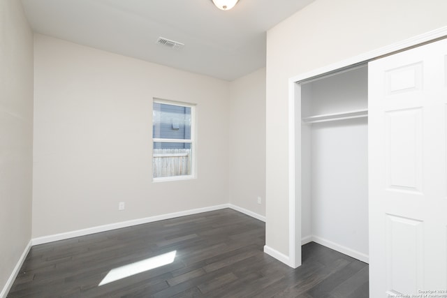 unfurnished bedroom featuring a closet and dark hardwood / wood-style floors