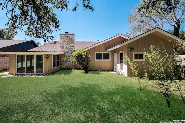 rear view of house featuring a lawn