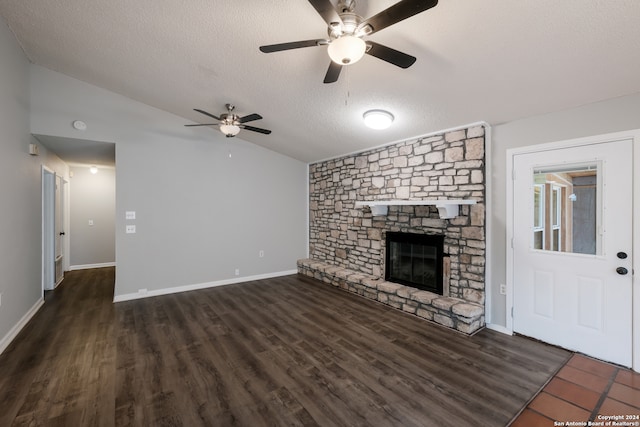 unfurnished living room with ceiling fan, lofted ceiling, a textured ceiling, a fireplace, and dark hardwood / wood-style flooring