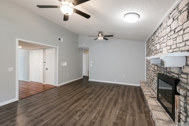 unfurnished living room featuring a textured ceiling, vaulted ceiling, a fireplace, dark hardwood / wood-style flooring, and ceiling fan