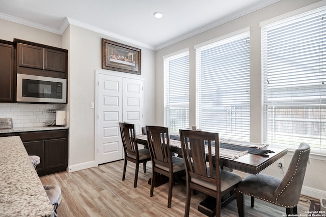 dining space featuring light hardwood / wood-style floors, plenty of natural light, and crown molding