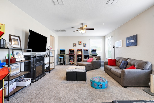 carpeted living room featuring ceiling fan and a textured ceiling