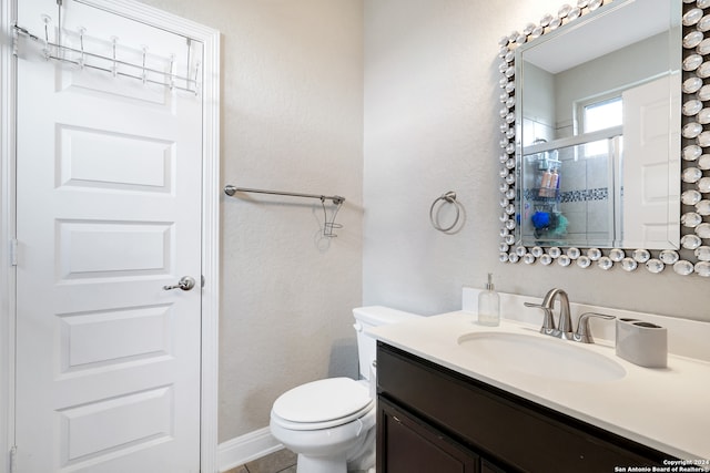 bathroom featuring walk in shower, vanity, tile patterned flooring, and toilet