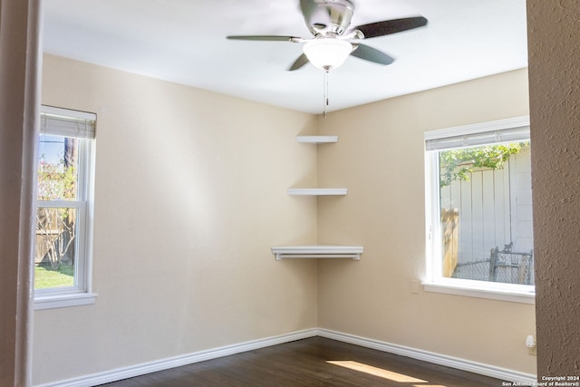 spare room featuring a wealth of natural light, ceiling fan, and dark hardwood / wood-style flooring