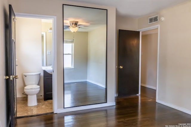 interior space with connected bathroom, ceiling fan, and dark hardwood / wood-style flooring