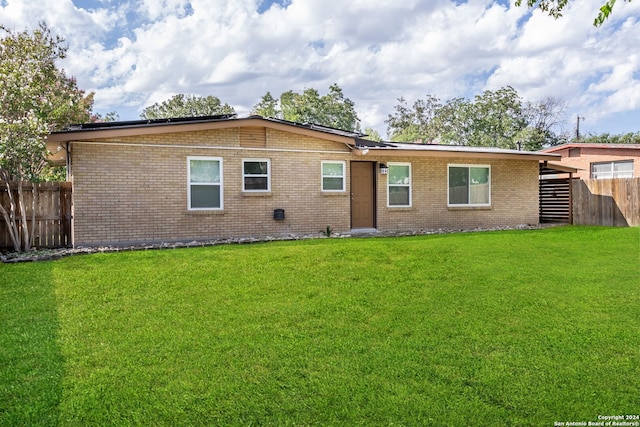 rear view of property featuring a lawn