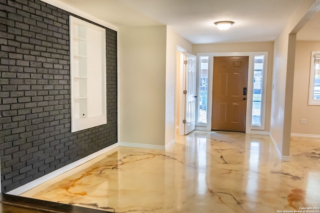 foyer featuring a healthy amount of sunlight and brick wall