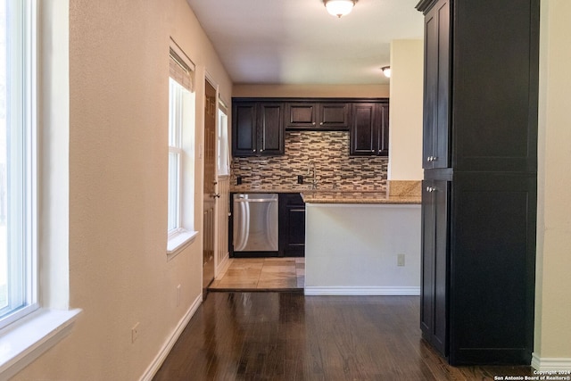 kitchen featuring sink, hardwood / wood-style floors, tasteful backsplash, and stainless steel dishwasher