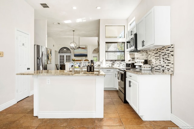 kitchen featuring light stone counters, a kitchen island with sink, white cabinets, hanging light fixtures, and stainless steel appliances