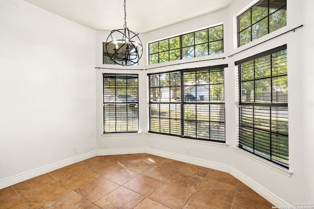 spare room featuring a high ceiling and a notable chandelier