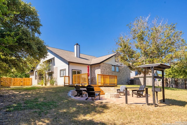 view of yard featuring a deck, an outdoor fire pit, and a patio area