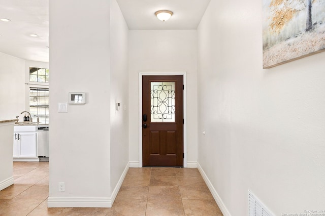 entrance foyer featuring light tile patterned floors and sink