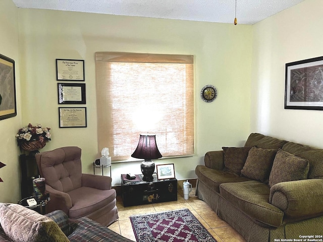 tiled living room featuring a textured ceiling