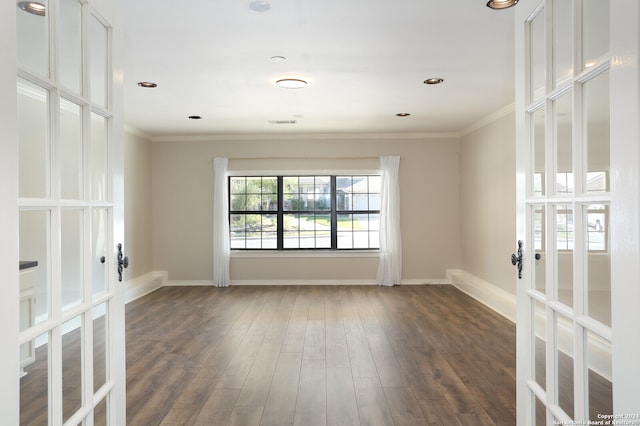 unfurnished room featuring french doors, crown molding, and dark wood-type flooring