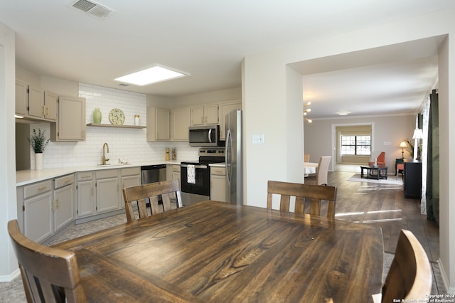 kitchen featuring tasteful backsplash, sink, gray cabinetry, appliances with stainless steel finishes, and dark hardwood / wood-style flooring