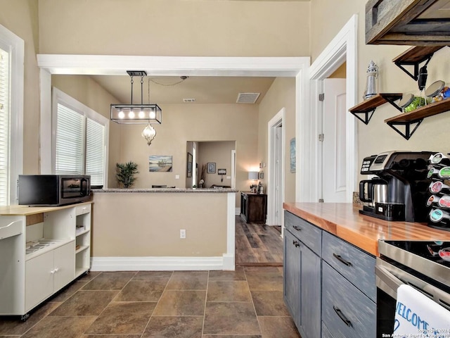 kitchen featuring gray cabinets, hanging light fixtures, and wood counters