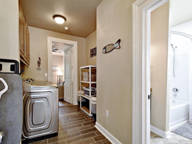 washroom featuring cabinets, a textured ceiling, independent washer and dryer, and dark hardwood / wood-style flooring