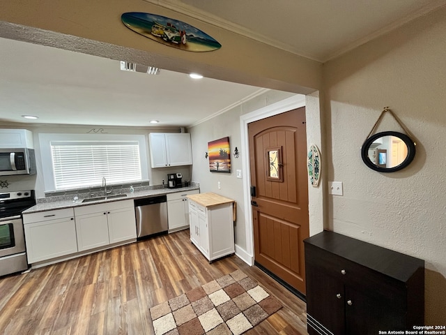 kitchen featuring white cabinets, sink, light hardwood / wood-style flooring, appliances with stainless steel finishes, and wood counters