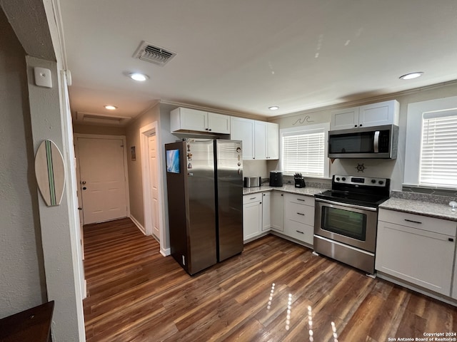 kitchen with stainless steel appliances, plenty of natural light, dark wood-type flooring, and white cabinetry