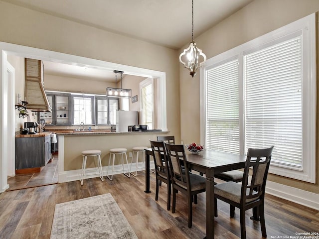 dining area with an inviting chandelier, dark hardwood / wood-style flooring, and sink