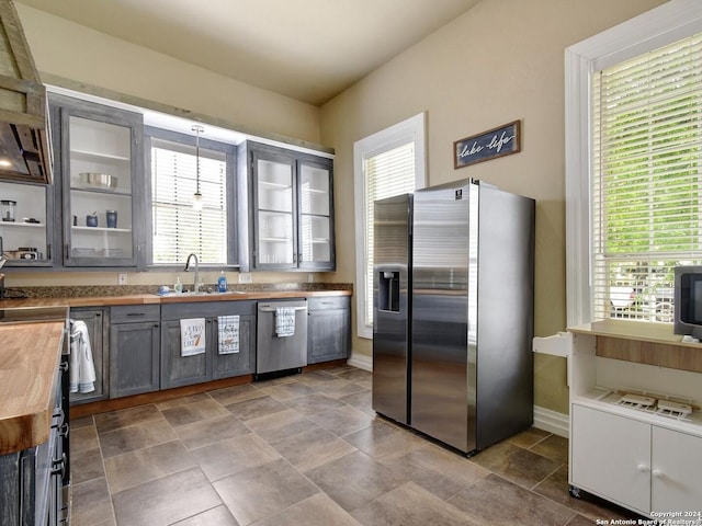 kitchen featuring a healthy amount of sunlight, wood counters, and stainless steel appliances