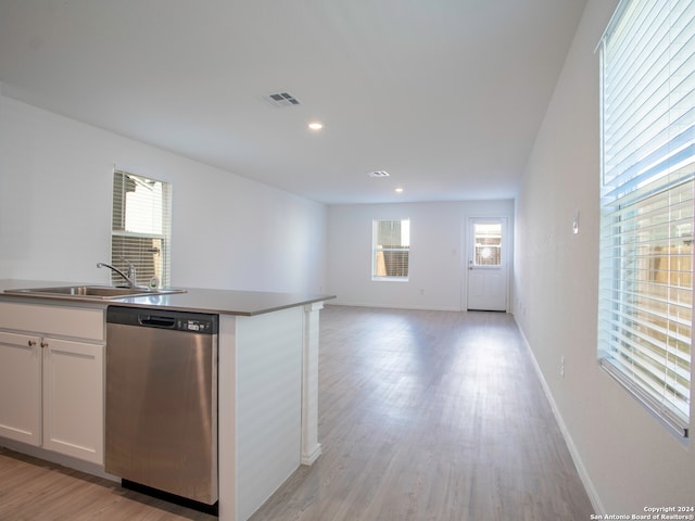 kitchen featuring sink, a center island with sink, light hardwood / wood-style flooring, white cabinetry, and dishwasher