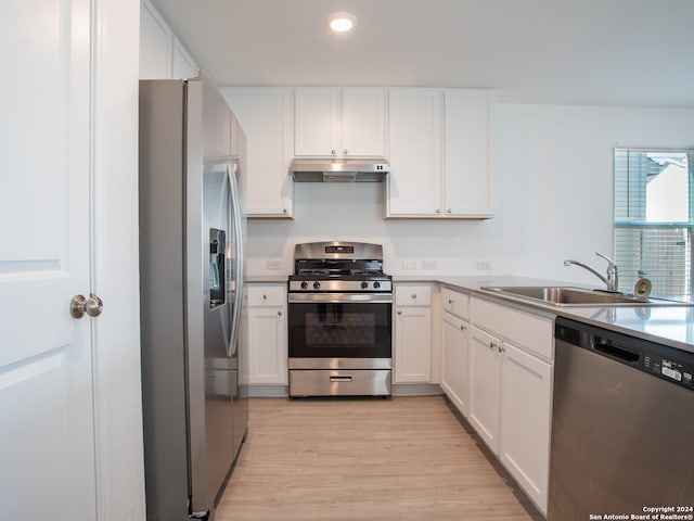 kitchen with sink, appliances with stainless steel finishes, light hardwood / wood-style floors, and white cabinetry