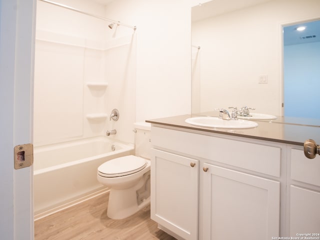 full bathroom with  shower combination, hardwood / wood-style flooring, vanity, and toilet