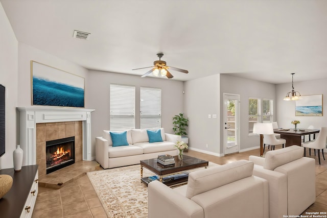 living area featuring a ceiling fan, a wealth of natural light, a fireplace, and visible vents