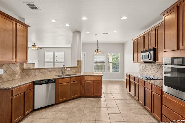 kitchen with pendant lighting, stainless steel appliances, decorative backsplash, and sink