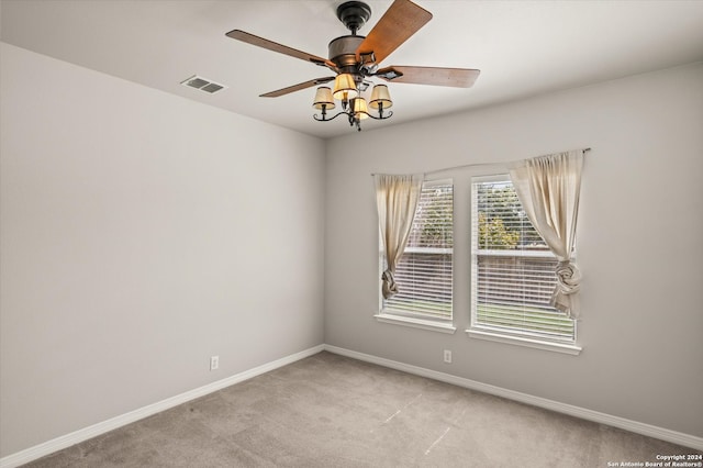 spare room with ceiling fan and light colored carpet