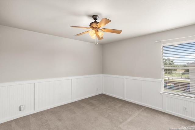 carpeted spare room featuring ceiling fan