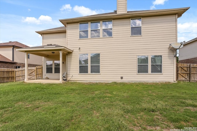 back of property with a lawn and a patio