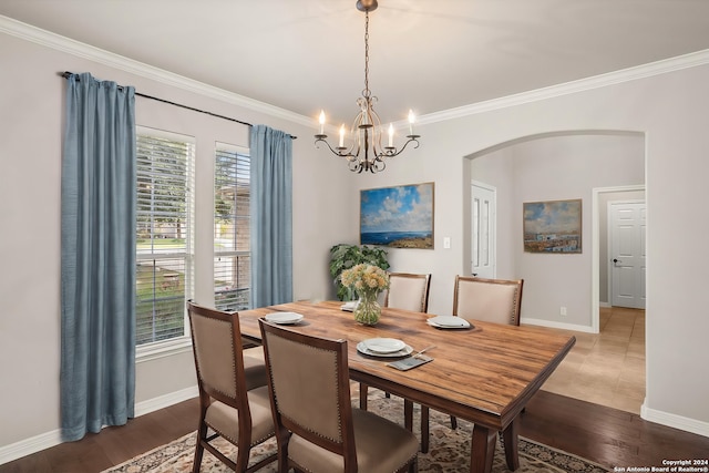 dining space featuring ornamental molding, an inviting chandelier, and hardwood / wood-style floors