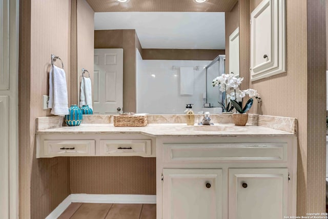 bathroom featuring tile patterned flooring, walk in shower, and vanity