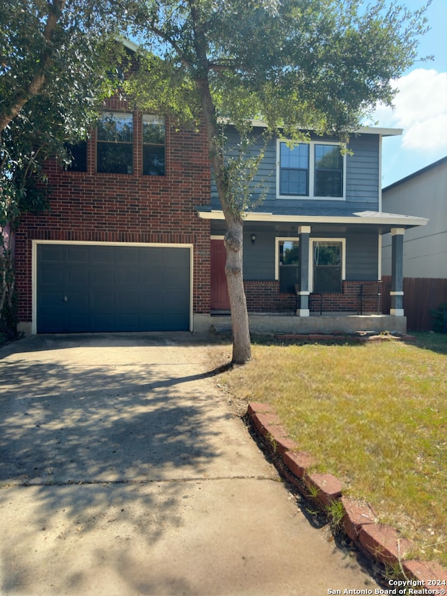 view of front facade featuring a front yard, a garage, and a porch