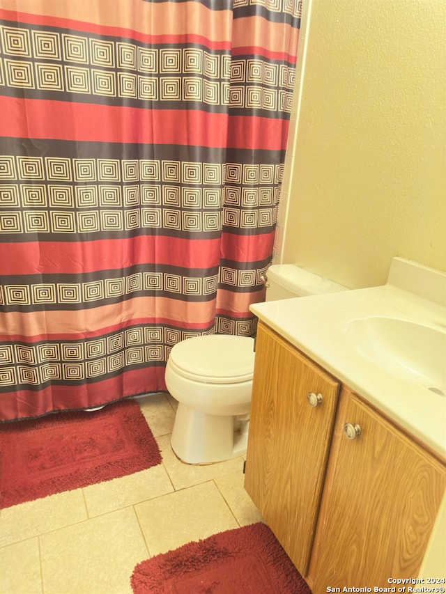 bathroom with vanity, toilet, a shower with shower curtain, and tile patterned floors