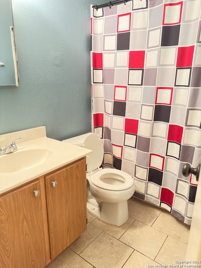 bathroom featuring curtained shower, vanity, toilet, and tile patterned floors