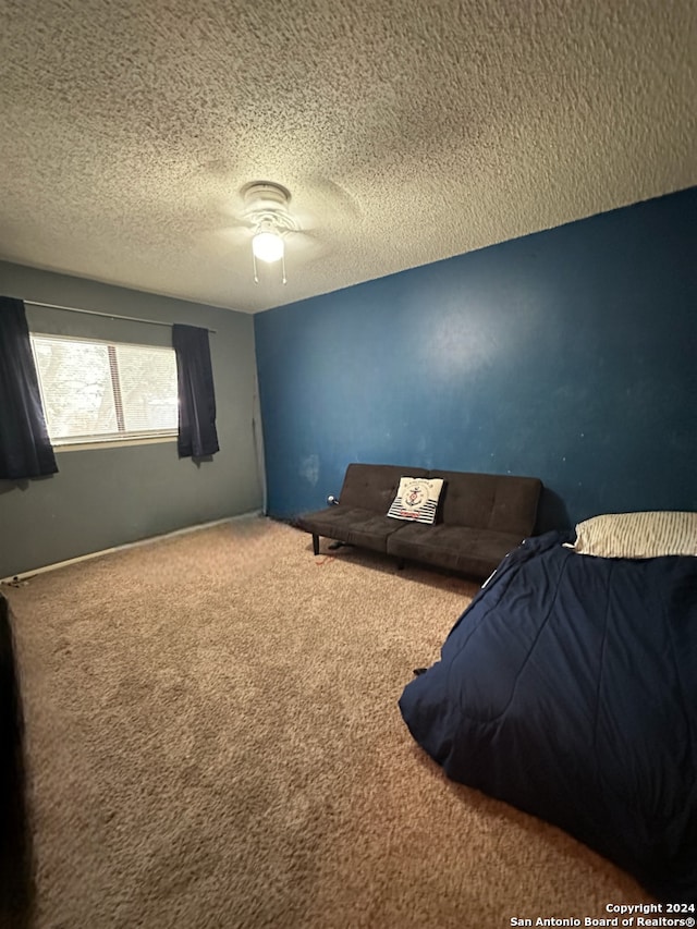 bedroom featuring carpet, ceiling fan, and a textured ceiling