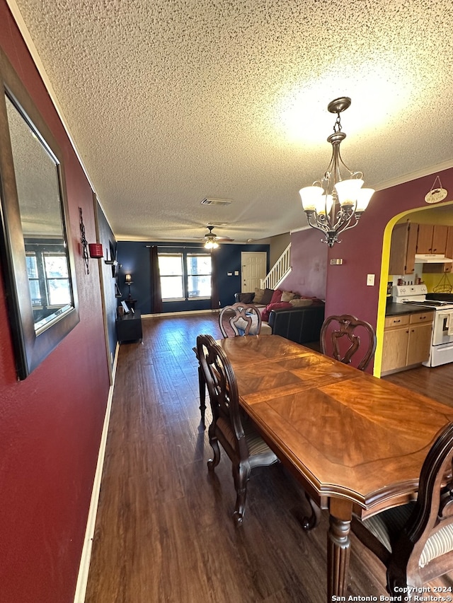 dining area featuring ornamental molding, a textured ceiling, ceiling fan with notable chandelier, and dark wood-type flooring