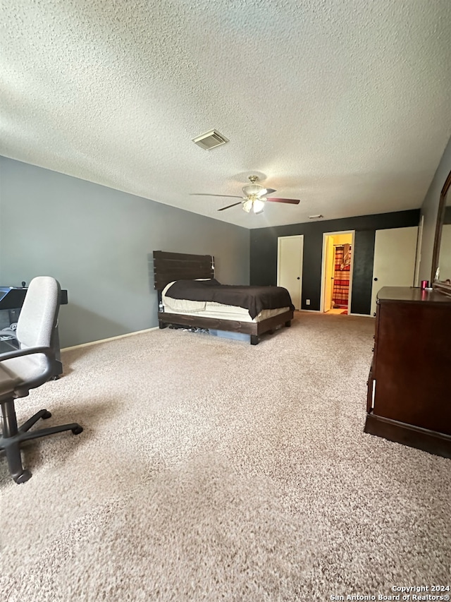 bedroom with a textured ceiling, carpet floors, and ceiling fan