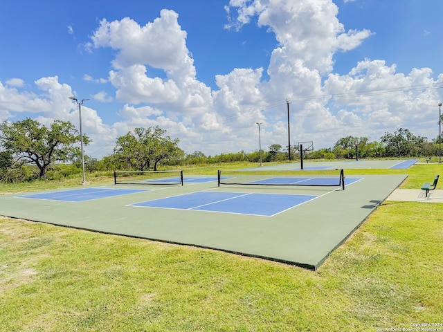 view of tennis court featuring a lawn