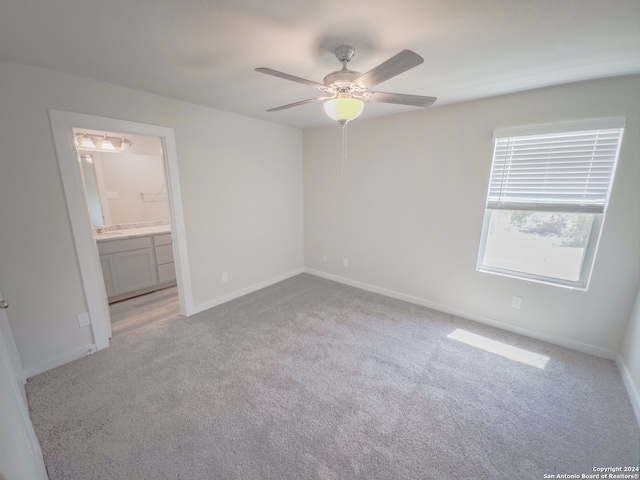 spare room featuring light carpet and ceiling fan