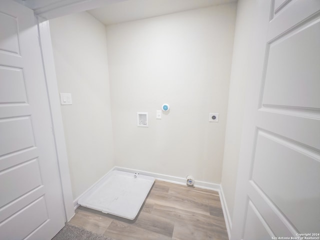 clothes washing area with light wood-type flooring, washer hookup, electric dryer hookup, and gas dryer hookup